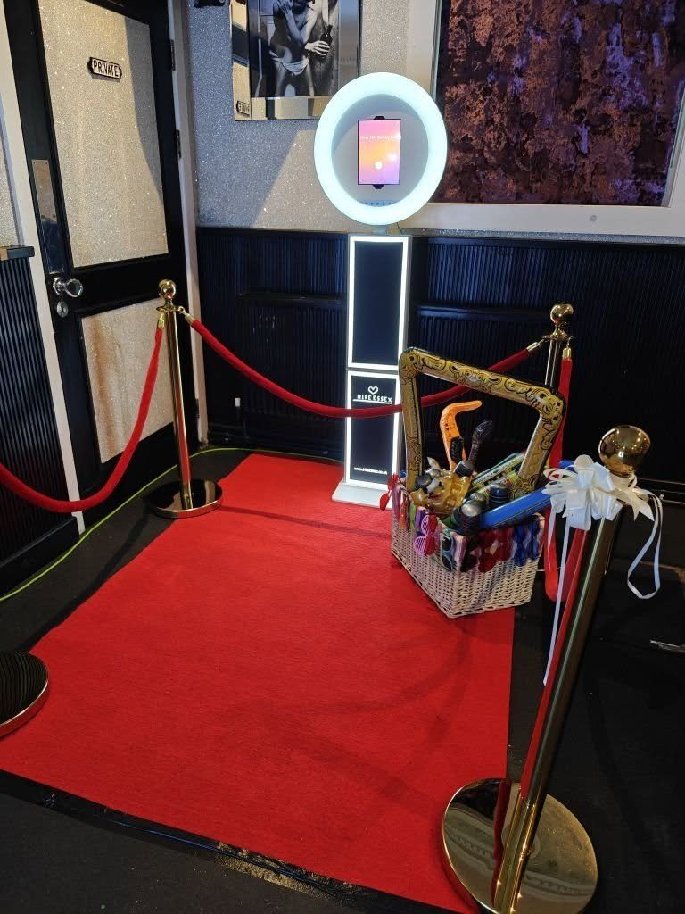 Photo booth with red carpet and prop basket at an Essex event